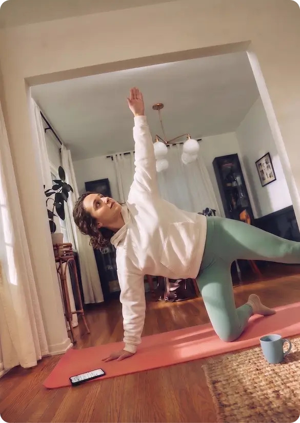 A resident stretching on a yoga mat in a well-kept living room